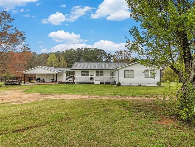 back of property with covered porch, a lawn, and a carport