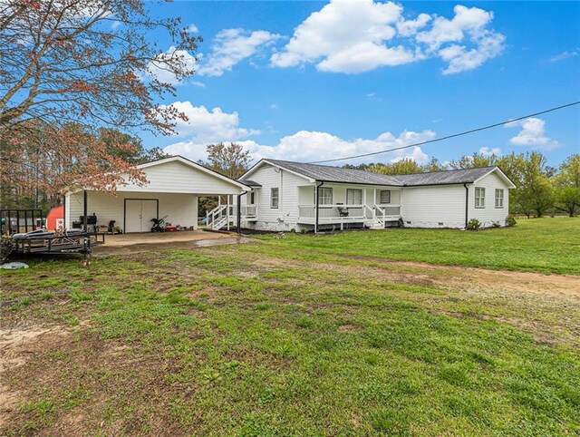 rear view of property with a lawn and a carport