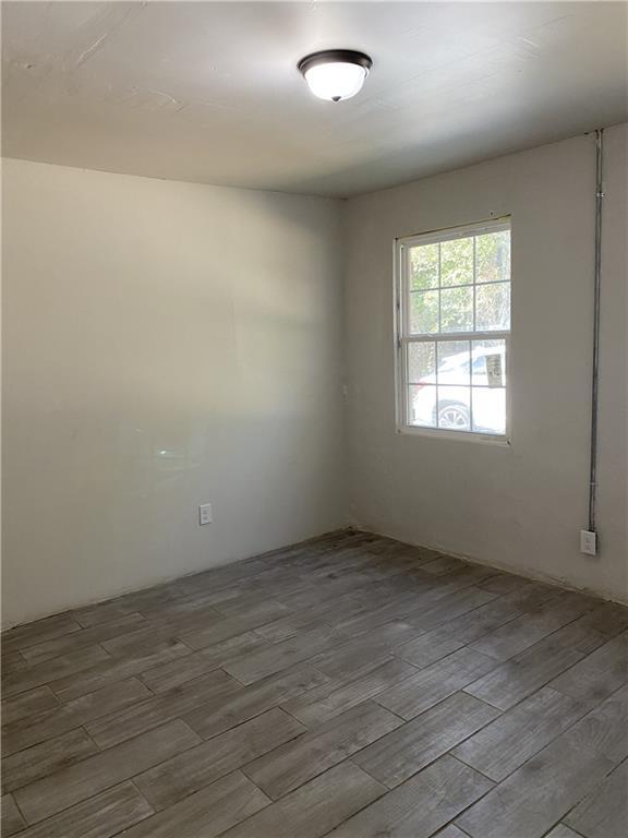 unfurnished room with wood finished floors