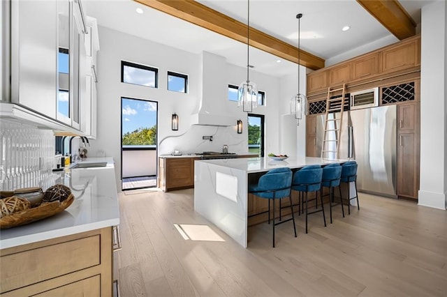 8200 Main St S Unit 1306, Woodstock, GA 30188 - kitchen with beam ceiling, freestanding refrigerator, light wood-style flooring, a sink, and a center island