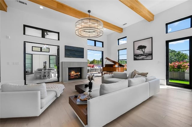 8200 Main St S Unit 1306, Woodstock, GA 30188 - living area featuring beamed ceiling, a lit fireplace, a high ceiling, a chandelier, and wood finished floors