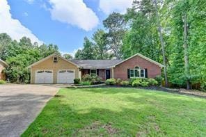 single story home featuring a front yard and a garage