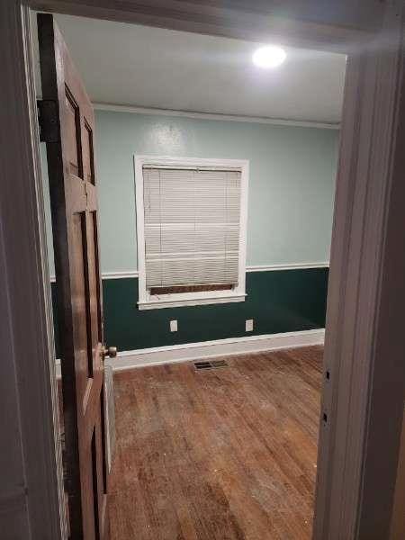 unfurnished room with crown molding and hardwood / wood-style floors