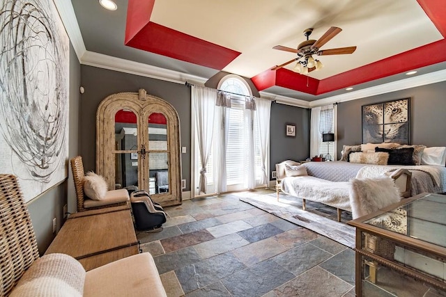 bedroom featuring crown molding, a tray ceiling, ceiling fan, and dark tile flooring