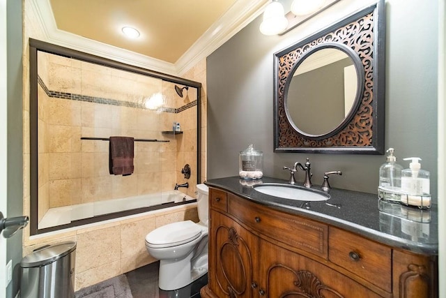 full bathroom featuring enclosed tub / shower combo, toilet, ornamental molding, and vanity with extensive cabinet space