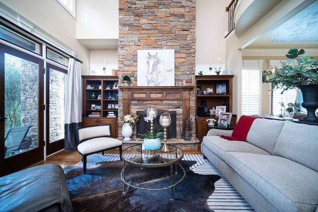 living room featuring dark wood-type flooring, a towering ceiling, and a fireplace