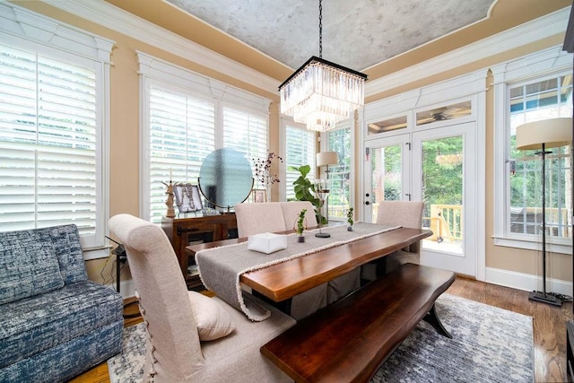 sunroom / solarium featuring french doors and an inviting chandelier