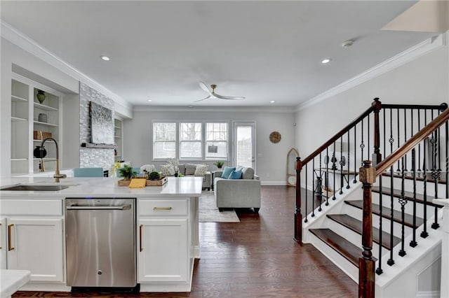 kitchen with ornamental molding, stainless steel dishwasher, a sink, and dark wood finished floors