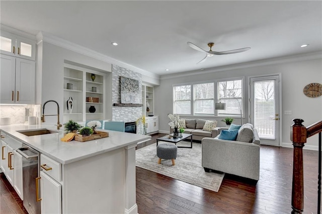 living area with baseboards, ceiling fan, ornamental molding, dark wood-type flooring, and built in shelves