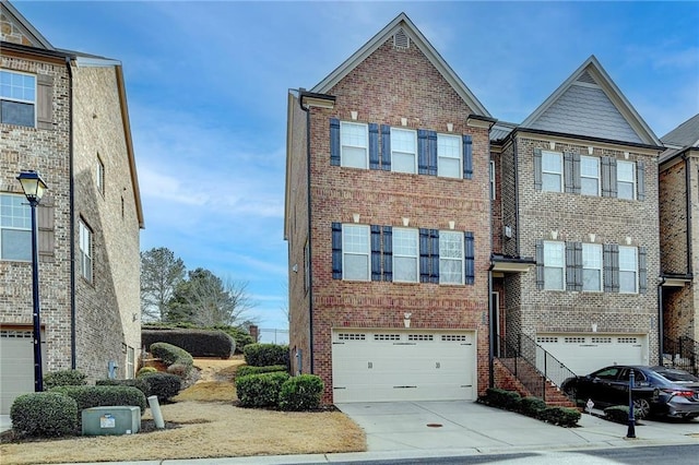 multi unit property featuring driveway, a garage, and brick siding