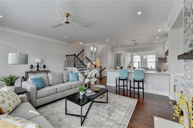 living area with baseboards, stairway, dark wood-style flooring, crown molding, and recessed lighting