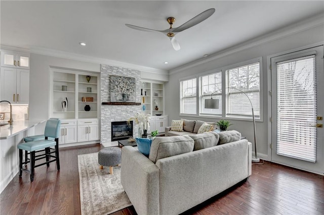 living room with a fireplace, dark wood finished floors, and crown molding