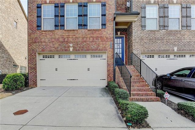 doorway to property with concrete driveway, brick siding, and an attached garage