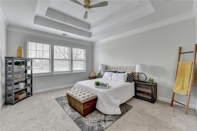 carpeted bedroom with baseboards, a tray ceiling, and crown molding