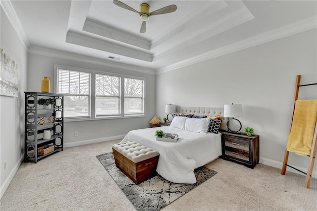 carpeted bedroom with baseboards, visible vents, ceiling fan, a tray ceiling, and crown molding