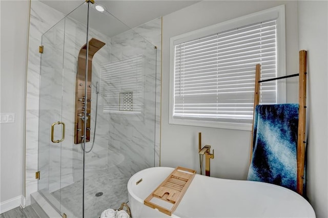 full bath featuring a soaking tub, a marble finish shower, and a wealth of natural light