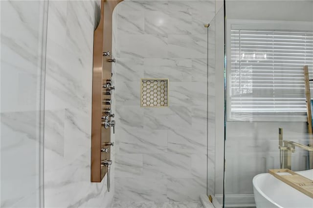 bathroom featuring a freestanding bath and a marble finish shower