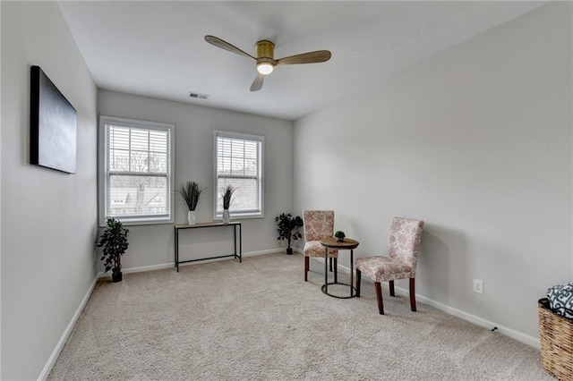 sitting room with ceiling fan, carpet flooring, visible vents, and baseboards