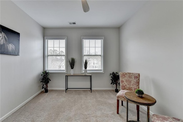 sitting room featuring carpet floors, visible vents, ceiling fan, and baseboards