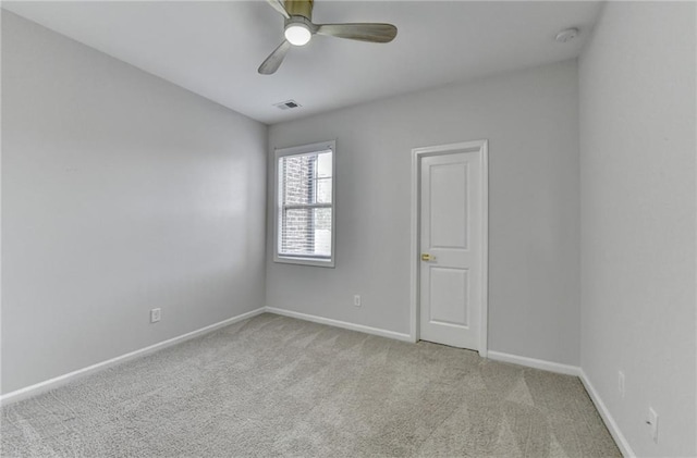 spare room featuring carpet floors, ceiling fan, visible vents, and baseboards