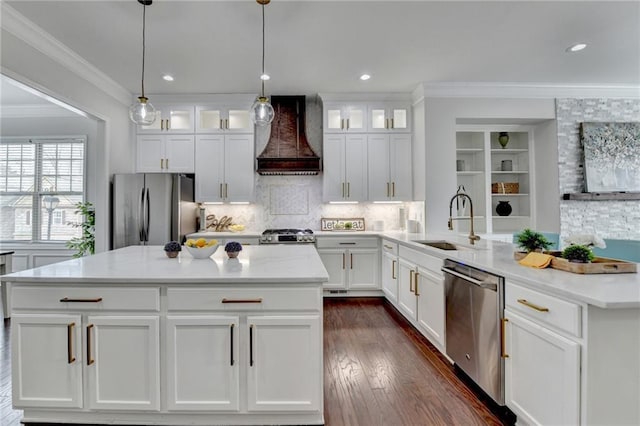 kitchen with dark wood-style floors, appliances with stainless steel finishes, custom exhaust hood, crown molding, and a sink