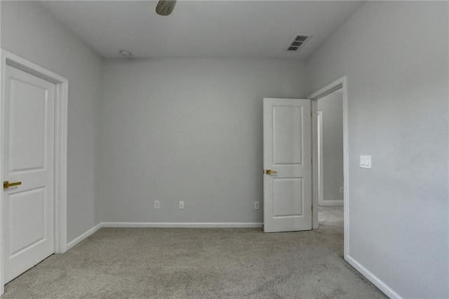 empty room featuring baseboards, visible vents, and carpet flooring