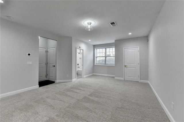 carpeted spare room featuring recessed lighting, visible vents, and baseboards