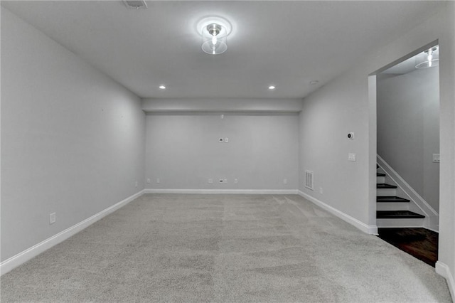 below grade area featuring carpet floors, recessed lighting, visible vents, baseboards, and stairs