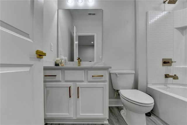 bathroom featuring visible vents, toilet, wood finished floors,  shower combination, and vanity