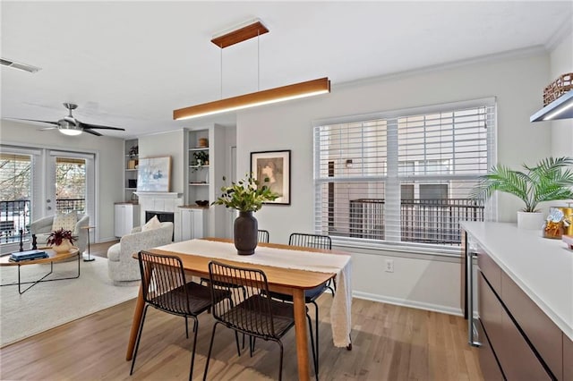 dining room with light hardwood / wood-style floors, ceiling fan, and ornamental molding