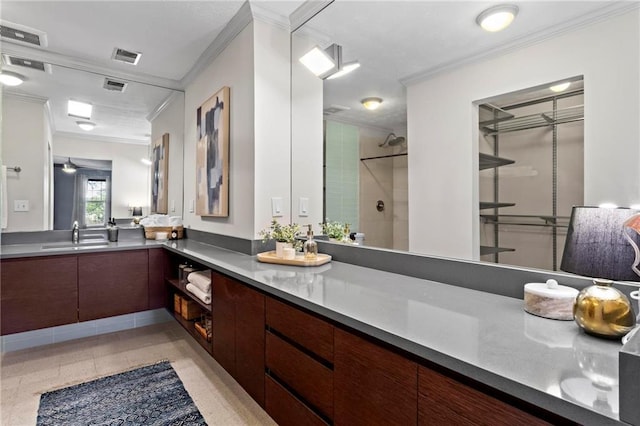 bathroom with tile patterned floors, vanity, crown molding, and a shower with shower door