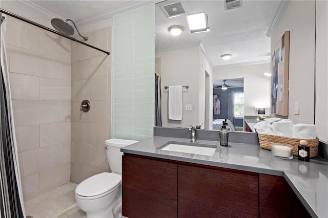 bathroom with vanity, crown molding, ceiling fan, toilet, and tiled shower