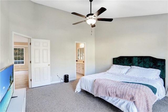 carpeted bedroom with ceiling fan, high vaulted ceiling, and ensuite bathroom