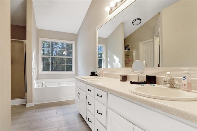 bathroom featuring shower with separate bathtub, vanity, and vaulted ceiling