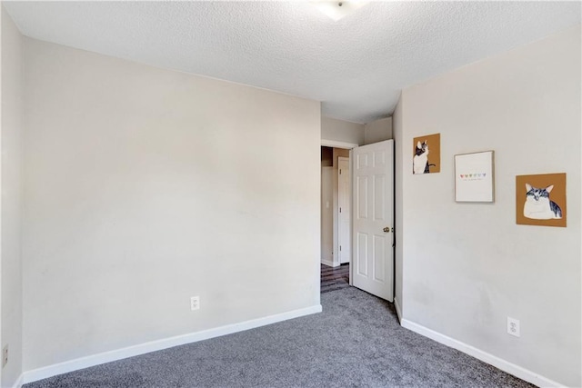 carpeted spare room with a textured ceiling