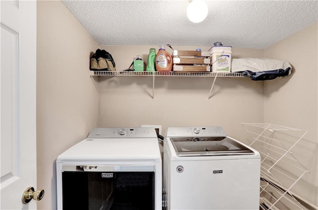 laundry area featuring a textured ceiling and washing machine and clothes dryer