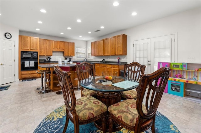 tiled dining area featuring french doors and sink