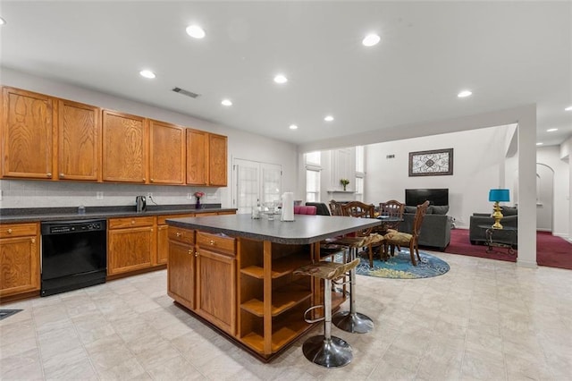 kitchen featuring a breakfast bar area, sink, dishwasher, and a kitchen island