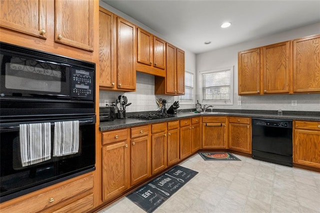 kitchen featuring backsplash, black appliances, and sink