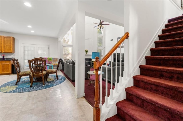 staircase with ceiling fan and tile patterned flooring