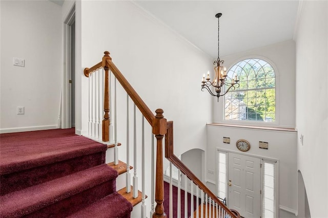 foyer entrance featuring an inviting chandelier and ornamental molding