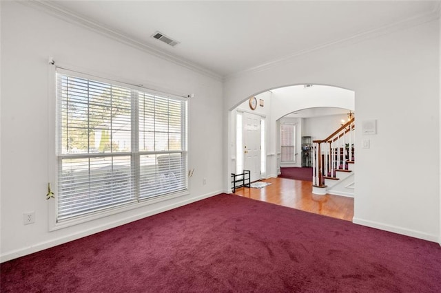 empty room featuring ornamental molding and carpet