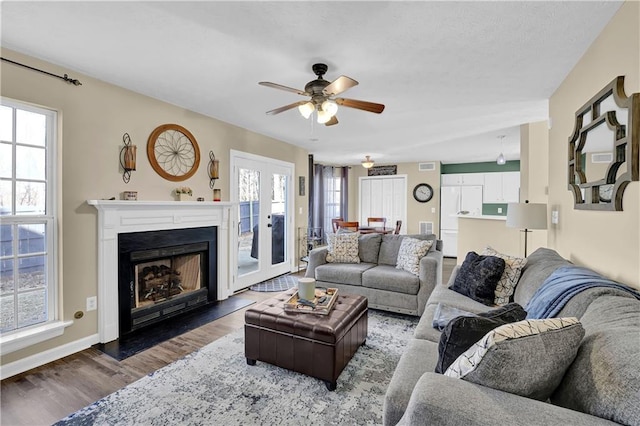 living room with ceiling fan and dark hardwood / wood-style flooring