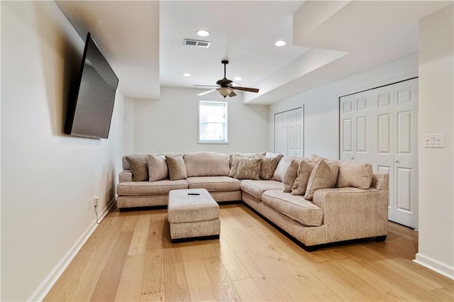 living room with ceiling fan and light hardwood / wood-style flooring