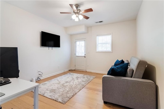 living room featuring ceiling fan and light wood-type flooring