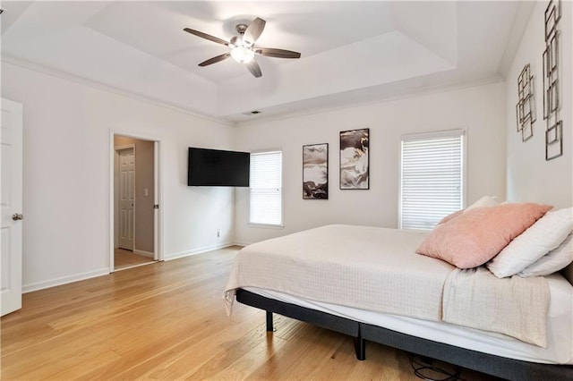 bedroom featuring hardwood / wood-style floors, ceiling fan, and a tray ceiling