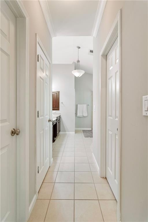 hallway with light tile patterned floors and ornamental molding