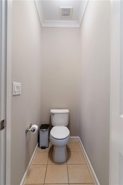 bathroom with tile patterned floors, toilet, and crown molding