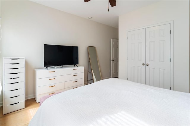 bedroom with ceiling fan, light hardwood / wood-style floors, and a closet