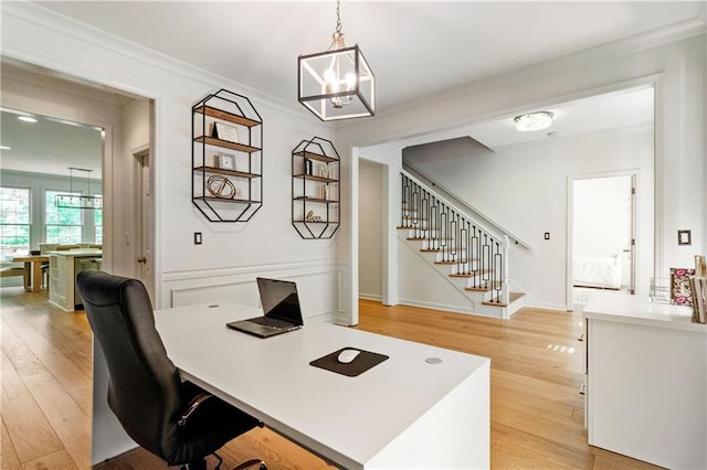 office area with light hardwood / wood-style flooring, crown molding, and a notable chandelier